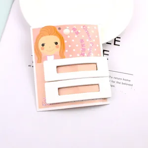 Gros plan de deux barrettes blanches rectangulaires pour infirmières sur carte rose