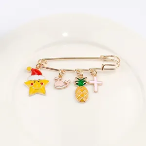 Détail de broche épingle à nourrice dorée avec breloques colorées en émail de dessin animé