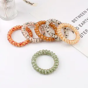 Set of 6 leopard print spiral hair coils in orange amber and beige on white background