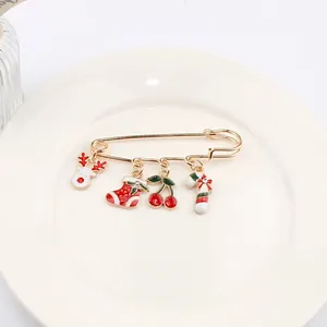 Détail de broche de Noël avec pendentifs renne, chaussette et sucre d'orge dorés