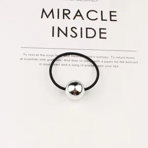 Minimalist black elastic hair tie featuring a polished silver bead on a stylish background