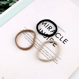 Three-piece braided high elasticity hair tie set in black and beige on an open magazine