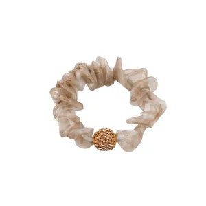 Champagne mesh scrunchie with crystal-encrusted ball detail on a white background