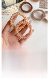 Detail of coffee-toned matte spiral hair ties with flexible high-elasticity texture