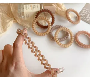 Close-up of matte coffee spiral hair ties showing high elasticity and soft texture
