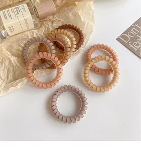 Detail of coffee-toned matte spiral hair ties with high elasticity in earth colors