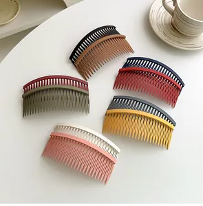 Macro shot of curved matte hair side combs in multiple Morandi colors on a white desk
