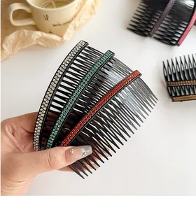 Detail of hand holding rhinestone-encrusted hair combs in various colors for hair styling