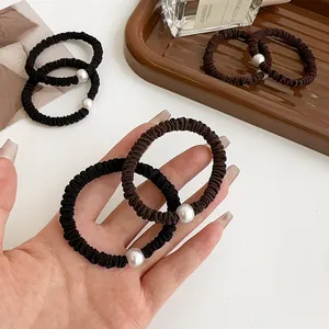 Elegantes gomas de pelo plisadas con perlas en negro y marrón oscuro con textura elástica
