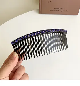 Detailed view of large black hair comb with rows of blue rhinestones for styling