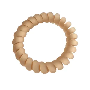 Matte nude spiral telephone wire hair tie with elastic seamless design on white background