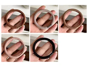 Set of five elastic hair ties in neutral earth tones showing fabric texture and stretch