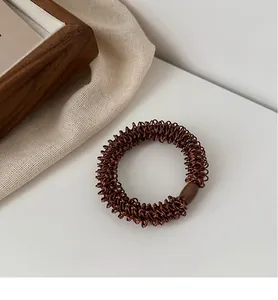 Détail d'un élastique à cheveux tressé marron foncé avec boucle en plastique durable