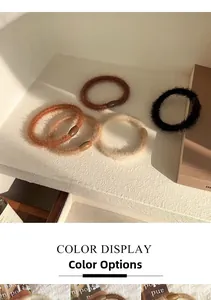 Detail of plush fuzzy hair ties in earthy tones with smooth oval plastic buckles