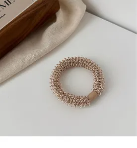 Gros plan détaillé de l'élastique à cheveux spirale champagne avec fermoir marron