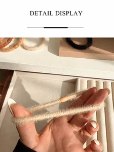 Detail of plush coffee-colored hair scrunchie with bead accent and soft furry texture