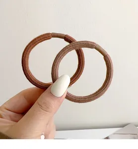 Detail of coffee and light brown thick hair ties with rib texture and smooth rubber seam
