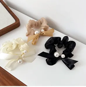 Detailed view of sheer mesh hair scrunchies with satin bows and elegant pearls