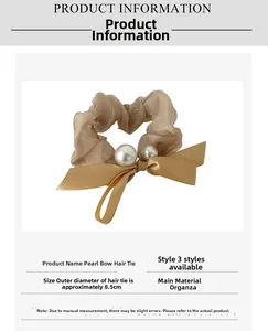 Detail view of champagne organza scrunchie with white pearls and bow design