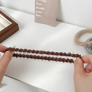 Élastiques à cheveux tressés épais à haute élasticité étirés sur un bureau blanc