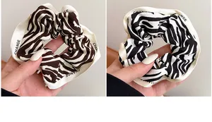 Detail of zebra pattern hair scrunchies with CHANGE printed white ribbon edges