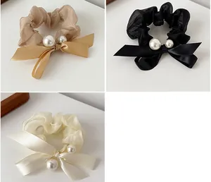 Three elegant mesh bow hair scrunchies with pearls in brown, black, and creamy white colors