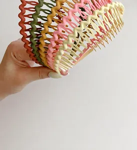 Detail of colorful wavy non-slip headbands held by hand in Morandi color palette