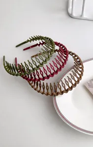 Detailed view of three matte non-slip headbands in dark green, burgundy, and brown