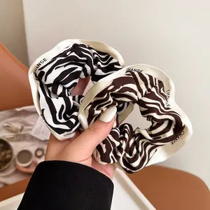 Zebra pattern hair scrunchies with CHANGE letter trim in black and brown knit fabric