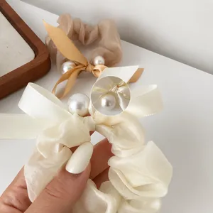 Elegant organza scrunchie with bow and hand-set pearls in cream and beige colors