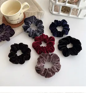 Set of large velvet scrunchies in 7 dark colors shown in a cozy home setting