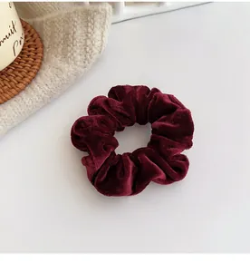 Detailed texture of burgundy velvet scrunchie on a cozy knitted background decor