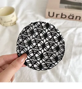 Gros plan sur un filet à cheveux en dentelle noire avec broderie florale et maille