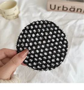 Détail d'un filet à cheveux noir élastique avec texture alvéolée fine et bordure en dentelle