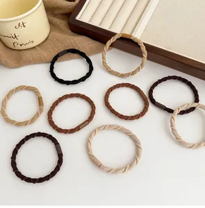Detailed view of elastic twisted hair ties in neutral tones like beige and brown