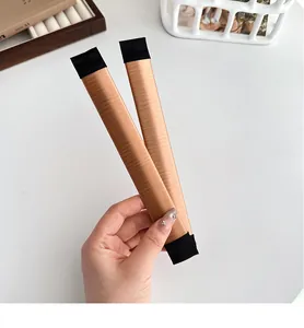Close-up of flexible brown satin hair bun maker tools for french twist styling