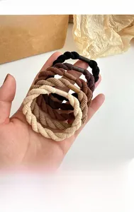 Dettaglio di elastici per capelli intrecciati spessi nei toni nero marrone e beige