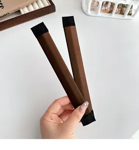 Detail of two dark brown synthetic hair bun makers for French hair styling