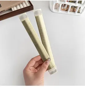 Close-up of champagne gold bun maker tools with fine ribbed texture held in hand