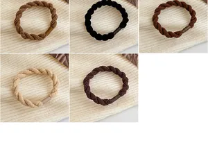 Vista dettagliata di elastici per capelli intrecciati in cinque colori neutri su maglia