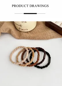 Detail of four spiral elastic hair ties in beige, brown, and black earth tones