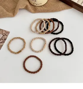 Macro detail of Earth-toned braided spiral hair ties with durable elastic inner core