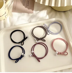 Détail d'un lot de 6 élastiques à cheveux avec perles en diverses couleurs dans un plateau