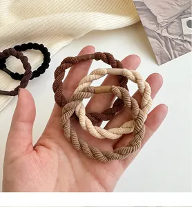 Dettaglio ravvicinato di elastici per capelli intrecciati in tonalità marrone e beige