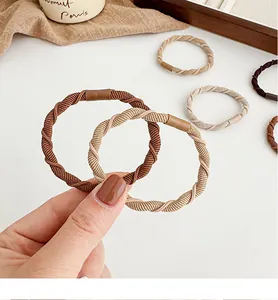 Macro detail of high-elastic spiral hair ties in earth-toned beige and coffee colors