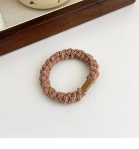 Dettaglio di un elastico per capelli intrecciato marrone caffè con fibbia quadrata opaca