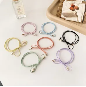 Close-up of colorful bow-style hair ties with gold metal accents on a white surface