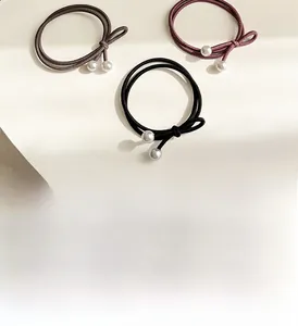 Détail de chouchous élastiques avec doubles perles élégantes en trois couleurs