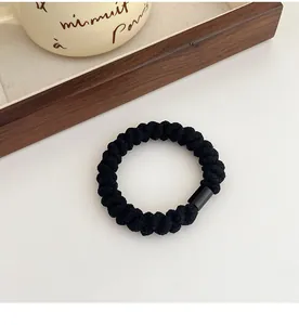 Dettaglio di un elastico per capelli intrecciato nero elastico con chiusura cilindrica