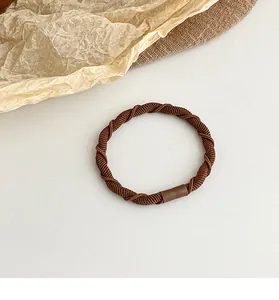 Detailed close-up of brown spiral twist elastic hair tie with durable fiber texture